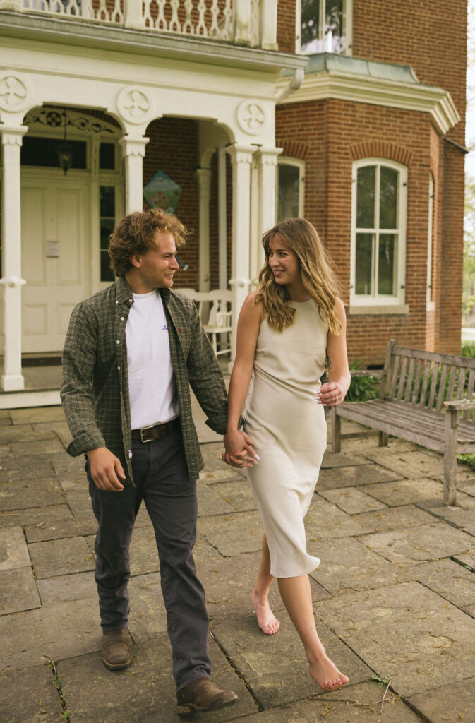 Natural, emotional moment of couple holding each other close in a vintage-inspired garden engagement session.